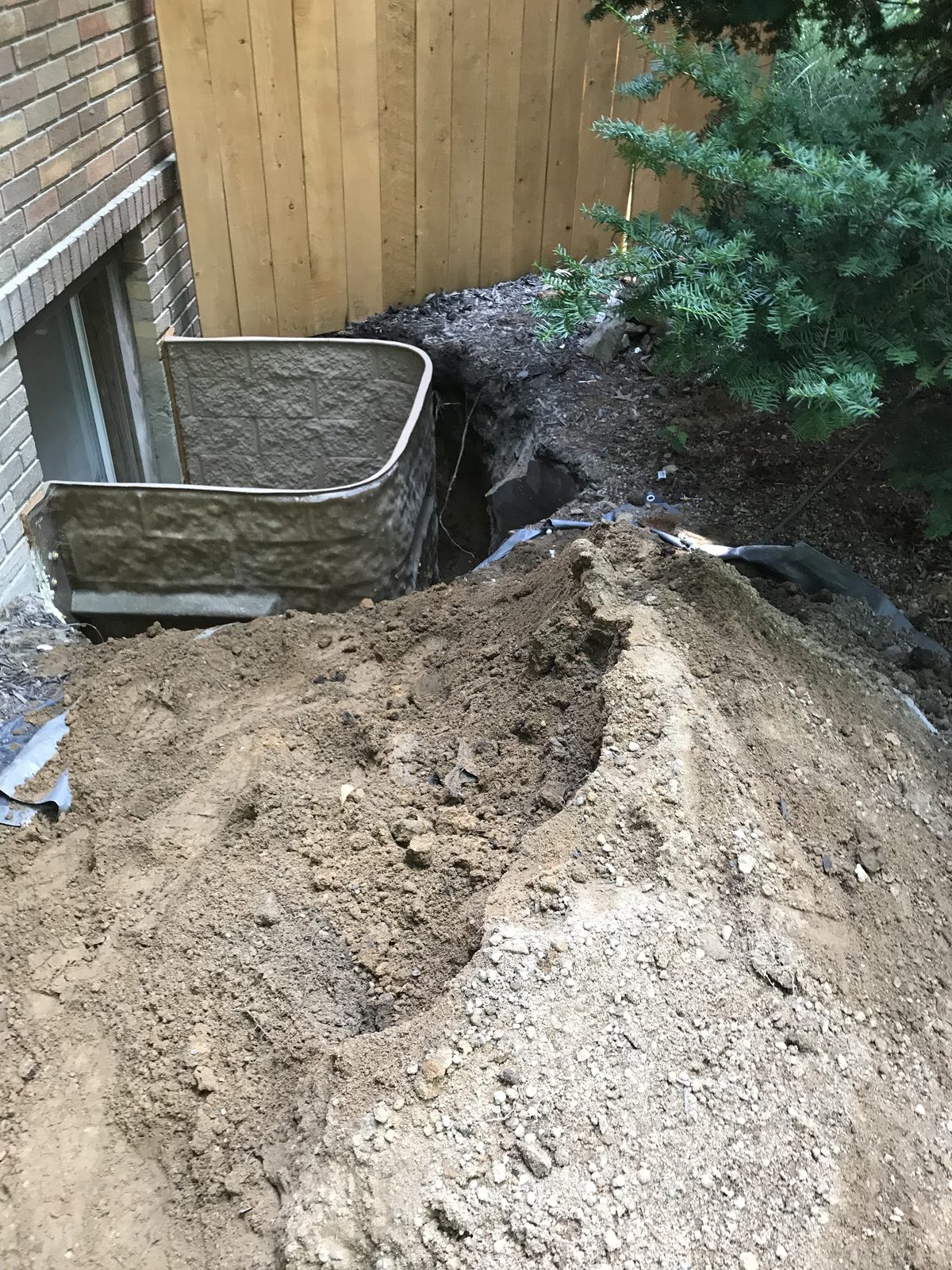 Egress window well installation in progress on a Grand Rapids home
