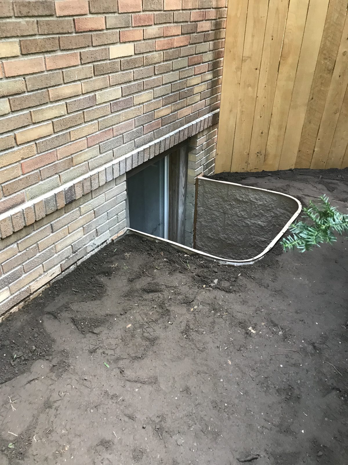Completed egress window well on a brick home in Grand Rapids, Michigan